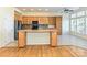 Well-lit kitchen boasts wood cabinets, tile backsplash, and stainless steel refrigerator at 315 Drake Park Ave, Fort Mill, SC 29708