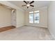 Bright and airy living room with a large window, ceiling fan, and neutral carpeting, creating a welcoming space at 315 Drake Park Ave, Fort Mill, SC 29708