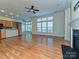 Open-concept living room with fireplace, hardwood floors, and large windows at 315 Drake Park Ave, Fort Mill, SC 29708