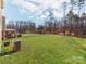 Large backyard with lush green lawn, treeline, and a gazebo-covered outdoor kitchen with grill at 3449 Southern Red Oak Ln, Gastonia, NC 28056