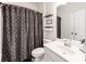 This full bathroom offers a single sink vanity, grey shower curtain, and decorative shelving at 3449 Southern Red Oak Ln, Gastonia, NC 28056