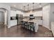 Spacious kitchen featuring white cabinets, stainless steel appliances, and a large island with bar stools at 3449 Southern Red Oak Ln, Gastonia, NC 28056