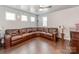 A spacious living room featuring hardwood floors, a ceiling fan, and a large leather sectional at 3449 Southern Red Oak Ln, Gastonia, NC 28056