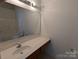 Well-lit bathroom vanity with a large mirror, white countertop, and tiled backsplash over a tiled floor at 3812 York Aly, Lake Park, NC 28079