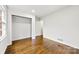 A bedroom featuring hardwood floors, closet, and doorways, offering a functional and clean living space at 3918 Woodgreen Ter, Charlotte, NC 28205