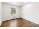 Serene bedroom with natural light from the window and gleaming wood floors create a relaxing atmosphere at 3918 Woodgreen Ter, Charlotte, NC 28205