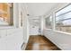 Sunroom with wood floor, many windows, white painted brick and walls, laundry hookup at 3918 Woodgreen Ter, Charlotte, NC 28205