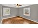 Bright bedroom featuring hardwood floors, two windows, a ceiling fan, and neutral wall paint at 428 Chester St, Lancaster, SC 29720