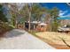 Charming brick home featuring a gravel driveway and beautiful landscaping on a sunny day at 428 Chester St, Lancaster, SC 29720