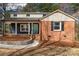 Inviting brick home features a front porch and a well-manicured yard with retaining wall landscaping at 428 Chester St, Lancaster, SC 29720