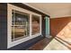 Covered front porch with large windows and a turquoise-colored front door, framed by brick at 428 Chester St, Lancaster, SC 29720
