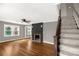 Bright living room featuring hardwood floors, a painted brick fireplace, and staircase at 428 Chester St, Lancaster, SC 29720