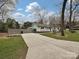 Charming light blue home with a welcoming front porch, a spacious driveway, and a partially fenced yard at 5091 Windward Dr, Tega Cay, SC 29708