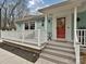 Inviting front porch with white railings and seating area, leading to a vibrant red front door at 5091 Windward Dr, Tega Cay, SC 29708