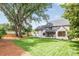 Lush backyard showcases a sprawling lawn and views of the home's exterior with mature trees at 5124 Lansing Dr, Charlotte, NC 28270