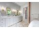 Elegant bathroom featuring a double vanity, stylish mirrors, and wood-look accent wall at 5124 Lansing Dr, Charlotte, NC 28270
