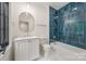 Stylish bathroom with blue tile accents, a bathtub, and a white vanity with sink at 5124 Lansing Dr, Charlotte, NC 28270
