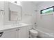 Well-lit bathroom features tile surround, and a vanity with stylish fixtures and ample counter space at 5124 Lansing Dr, Charlotte, NC 28270