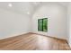 Bright bedroom with hardwood floors and a black framed window overlooking lush greenery at 5124 Lansing Dr, Charlotte, NC 28270