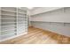 Bright walk-in closet with hardwood floors, custom shelving, and hanging racks at 5124 Lansing Dr, Charlotte, NC 28270
