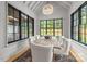 Bright dining area with vaulted ceilings, expansive windows overlooking the lush backyard, and modern furnishings at 5124 Lansing Dr, Charlotte, NC 28270