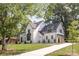 Beautiful white painted brick home with a walkway and a large well-maintained lawn and mature trees at 5124 Lansing Dr, Charlotte, NC 28270