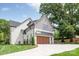 Charming exterior features a lush yard, stone accents, and a two-car garage with a private entrance at 5124 Lansing Dr, Charlotte, NC 28270