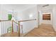 Bright hallway featuring wooden floors, white railings, and an elegant hanging light fixture at 5124 Lansing Dr, Charlotte, NC 28270