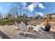 Backyard patio featuring stone fire pit with Adirondack chairs, and professionally landscaped yard at 5367 Heartwood Ln, Denver, NC 28037