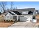 Charming single-Gathering home featuring stone accents, a two-car garage, and a well-manicured front yard at 5367 Heartwood Ln, Denver, NC 28037