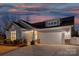 Beautiful single-Gathering home at dusk featuring stone accents, a two-car garage, and a well-manicured front yard at 5367 Heartwood Ln, Denver, NC 28037
