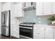 Modern kitchen featuring stainless steel appliances, white cabinets, and stylish backsplash at 5367 Heartwood Ln, Denver, NC 28037