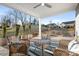 Covered patio features a ceiling fan, comfortable seating, and a view of the landscaped backyard and blue skies at 5367 Heartwood Ln, Denver, NC 28037