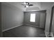 This bedroom features grey wood floors, light grey walls and a tray ceiling with fan at 5809 Carolina Manor Ct, Indian Trail, NC 28079