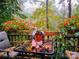 Outdoor seating area with charming table, chair, and a pot of plants with a view of the colorful trees at 5912 Potter S Rd, Waxhaw, NC 28173