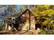 Charming log home featuring a brick foundation, triangular windows, and a deck with beautiful landscaping at 5912 Potter S Rd, Waxhaw, NC 28173