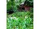 A picturesque wooded yard surrounds a cozy log home with a beautiful brick foundation and an upper deck at 5912 Potter S Rd, Waxhaw, NC 28173