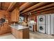 Kitchen features oak cabinets, ceiling beams, white appliances and a stacked washer/dryer combo at 5912 Potter S Rd, Waxhaw, NC 28173