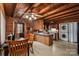Kitchen and laundry featuring wood paneling, ceiling beams, oak cabinets, and stacked washer and dryer at 5912 Potter S Rd, Waxhaw, NC 28173