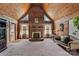 Vaulted ceiling and exposed wood walls make this living room feel warm and spacious, with a brick fireplace as a focal point at 5912 Potter S Rd, Waxhaw, NC 28173