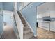 View of the carpeted stairway leading to the second story, and the kitchen through an archway at 7138 Stonington Ln, Charlotte, NC 28227
