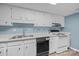 Kitchen with white cabinets, countertops, and appliances with hardwood flooring at 7138 Stonington Ln, Charlotte, NC 28227