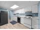 Kitchen with white cabinets, countertops, and appliances with hardwood flooring at 7138 Stonington Ln, Charlotte, NC 28227