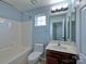 Bathroom featuring a shower-tub combo, single sink vanity, and a window at 8017 Talcott Dr, Mint Hill, NC 28227