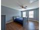 This bedroom features a ceiling fan, two windows, hardwood floors and light blue paint at 8017 Talcott Dr, Mint Hill, NC 28227