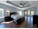 Spacious bedroom with a tray ceiling, ceiling fan, and dark wood flooring at 8017 Talcott Dr, Mint Hill, NC 28227