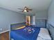 Bedroom with blue walls, ceiling fan, and doorway to the house's interior at 8017 Talcott Dr, Mint Hill, NC 28227