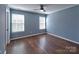 Bedroom featuring two windows, hardwood flooring, and a neutral color palette at 8017 Talcott Dr, Mint Hill, NC 28227