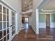 Grand foyer with hardwood floors, staircase with iron railings, and views into adjoining living spaces at 8017 Talcott Dr, Mint Hill, NC 28227