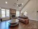 Open-concept living room with a stone fireplace, wood floors, and high ceilings at 8017 Talcott Dr, Mint Hill, NC 28227